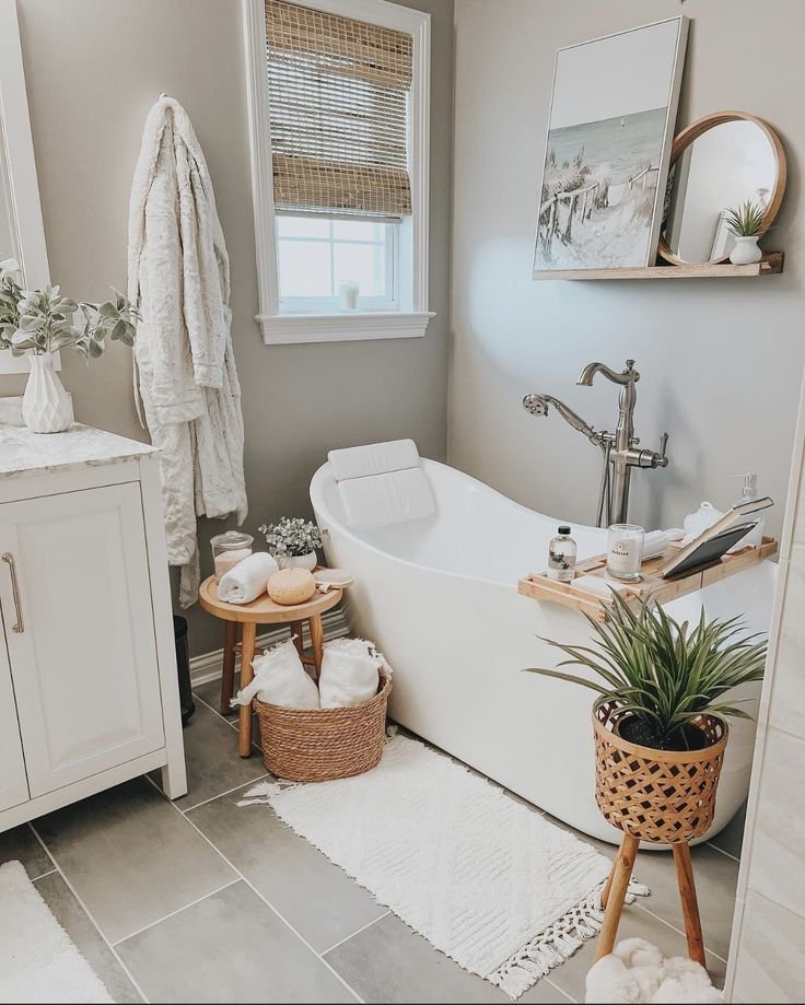 Spa-style bathroom with warm lighting, rounded tub edges and a few styled accessories on the tub ledge