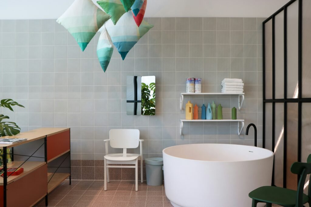 White floating shelves holding folded towels and colorful bottles mounted above a round white soaking tub