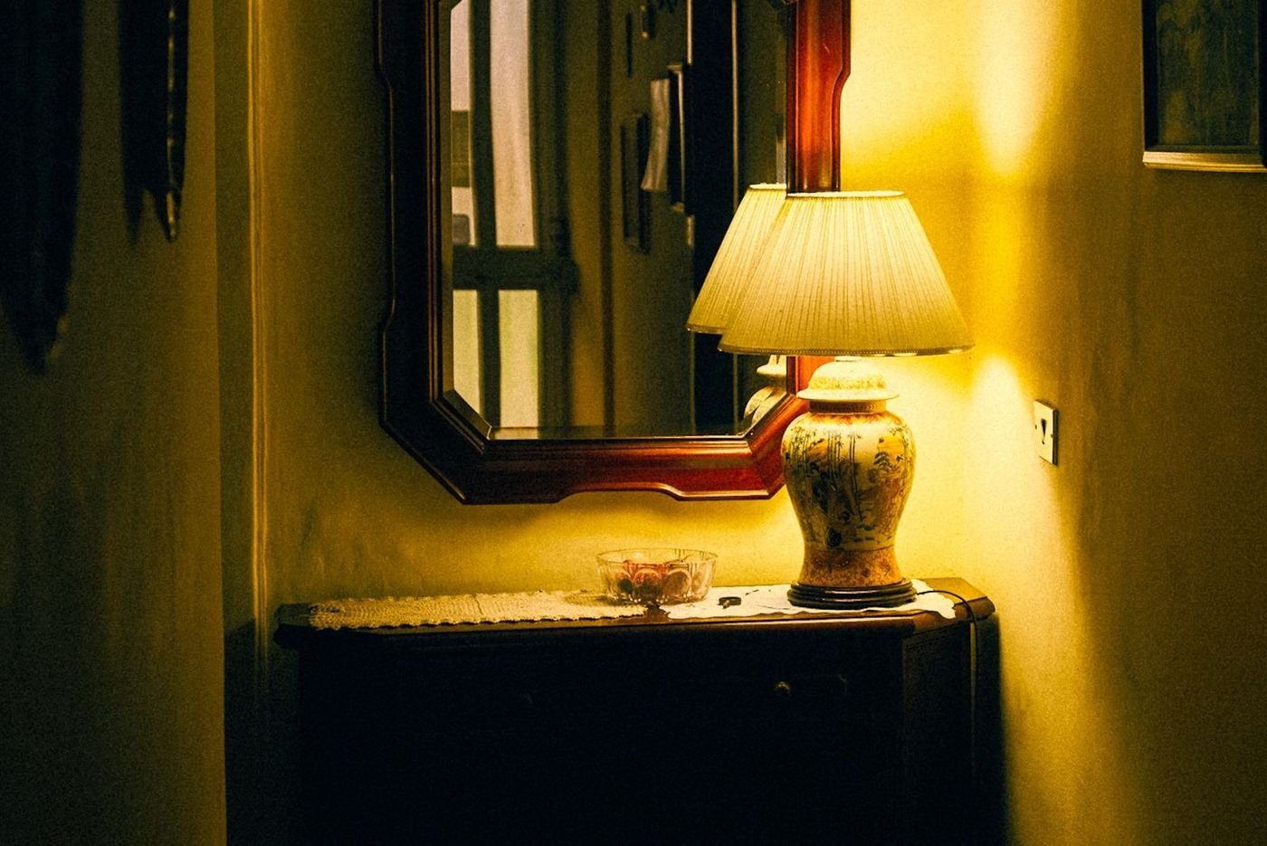 Vintage-style console table styled with a mirror, lamp and small bowl
