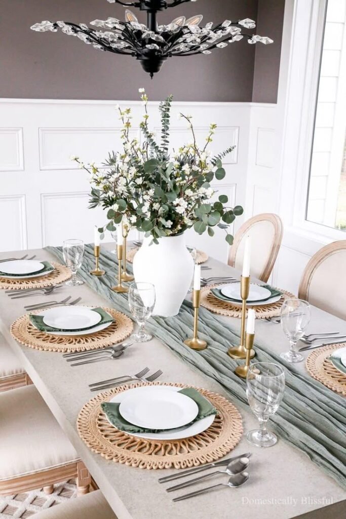 Dining table styled with layered place settings, candles and mixed metal accents