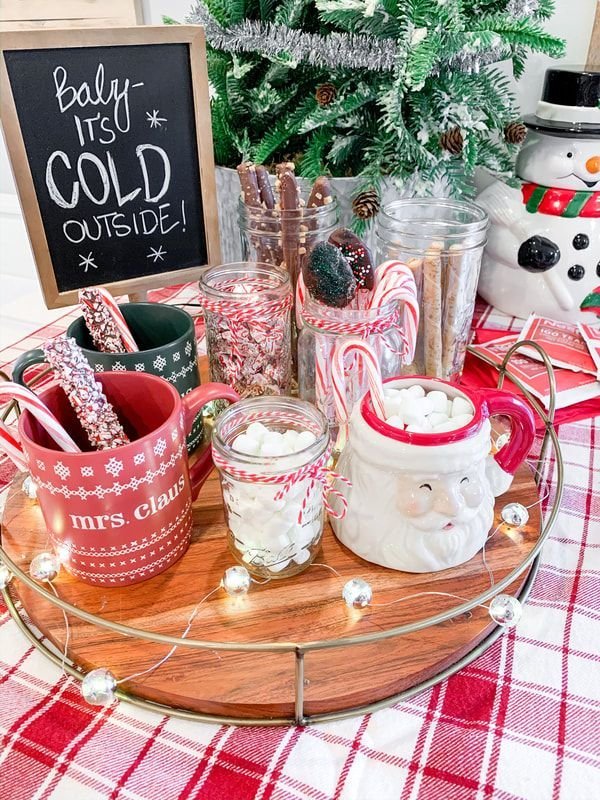 Hot cocoa bar accented with seasonal decor like pinecones and greenery