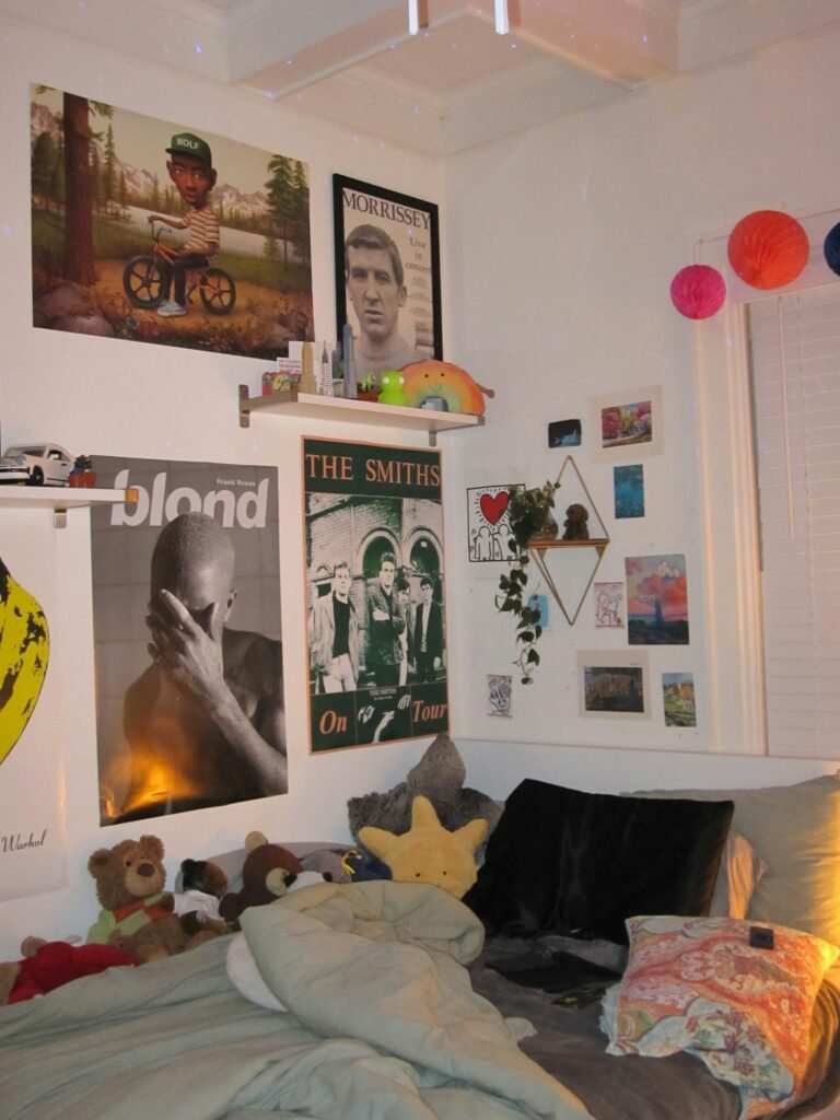 Bedroom doorway opening onto a wall covered in framed and printed band posters, paper lanterns and a small shelf of collectibles