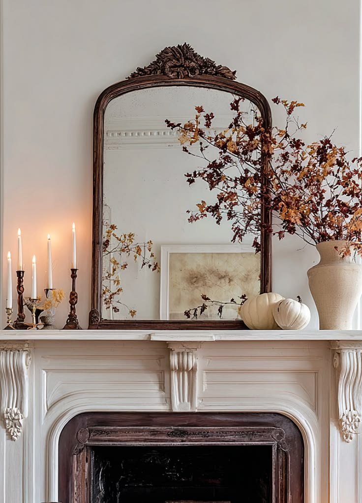 Antique mirror with autumn branches and pumpkins styled on a fall mantel