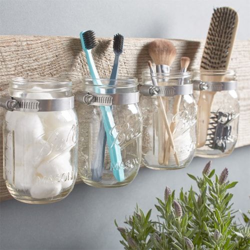 Clear Mason jar used to organize toothbrushes on a bathroom counter