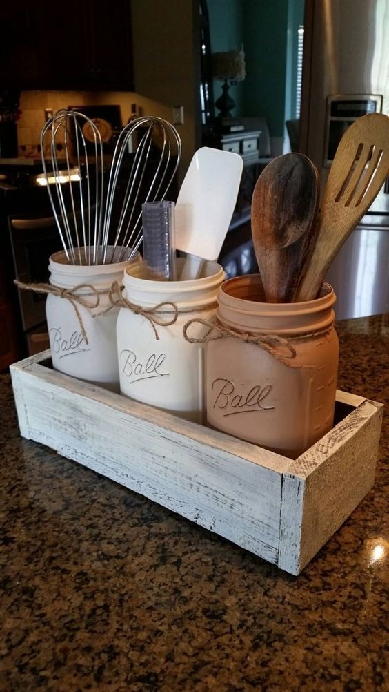 Rustic kitchen shelf lined with Mason jars storing dried goods and utensils