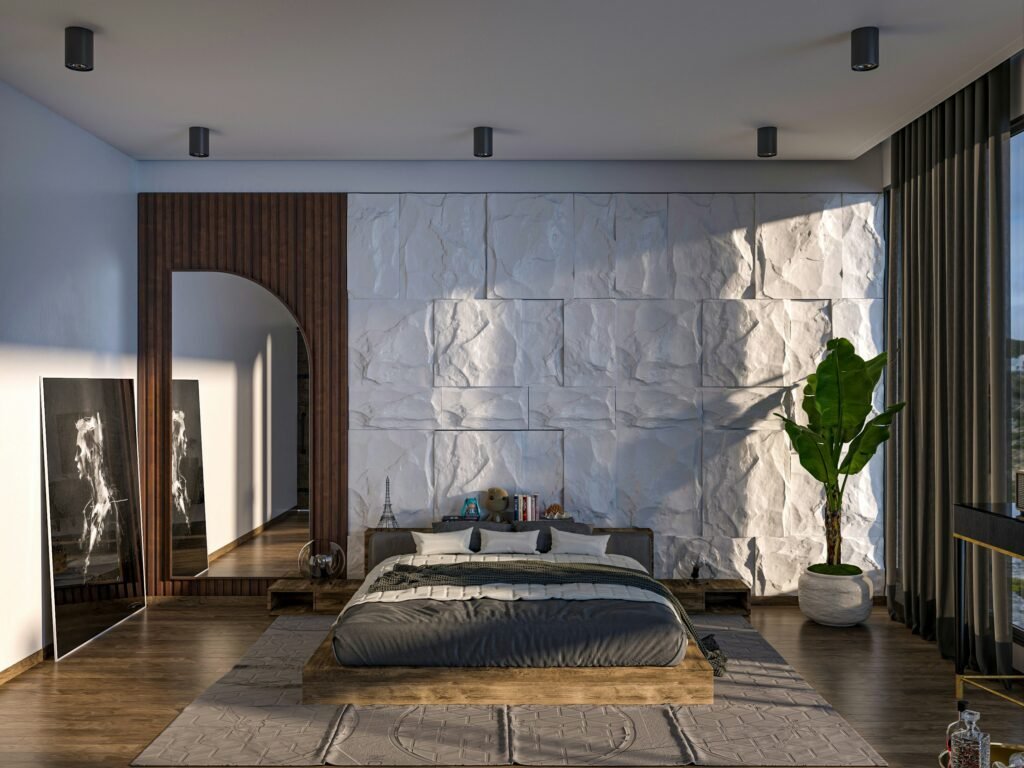 Large leaning floor mirror set against a dramatic textured white stone accent wall in a bedroom