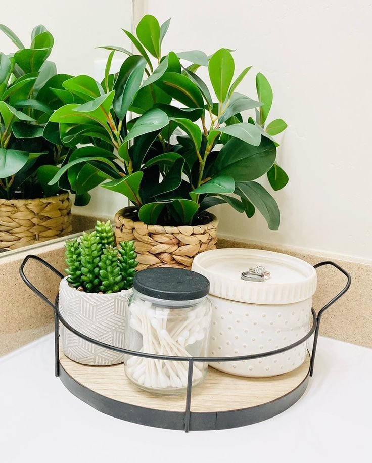Round tray styling a corner of a bathroom counter with soap and a small plant