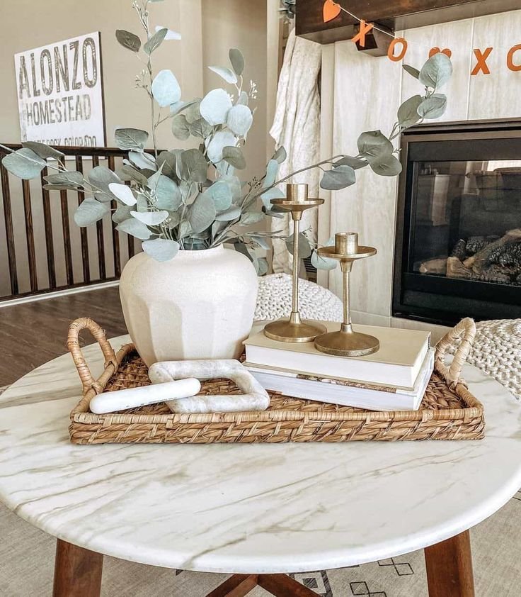 Round tray styled as a coffee table centerpiece with a vase, candle and books
