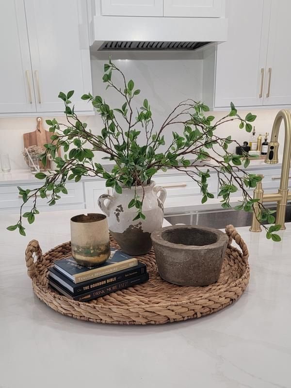 Braided round tray with natural texture styled with a vase and greenery