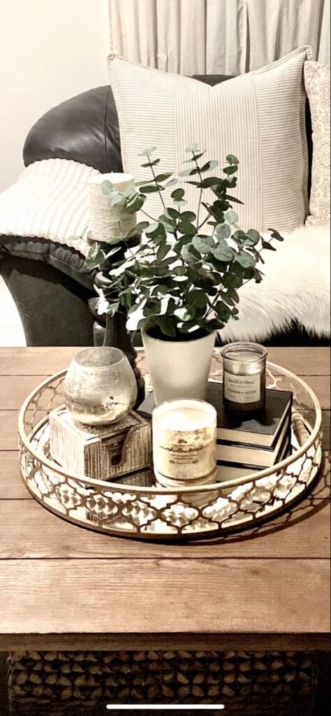 Farmhouse-style round tray with a gold mirror styled on a coffee table