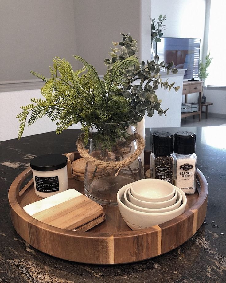 Round tray styled with a vase and candle on a kitchen counter
