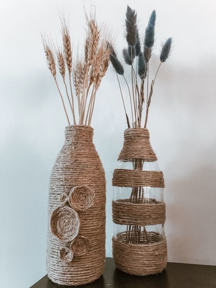 Twine-wrapped glass bottles with small flower stems styled on a wood table