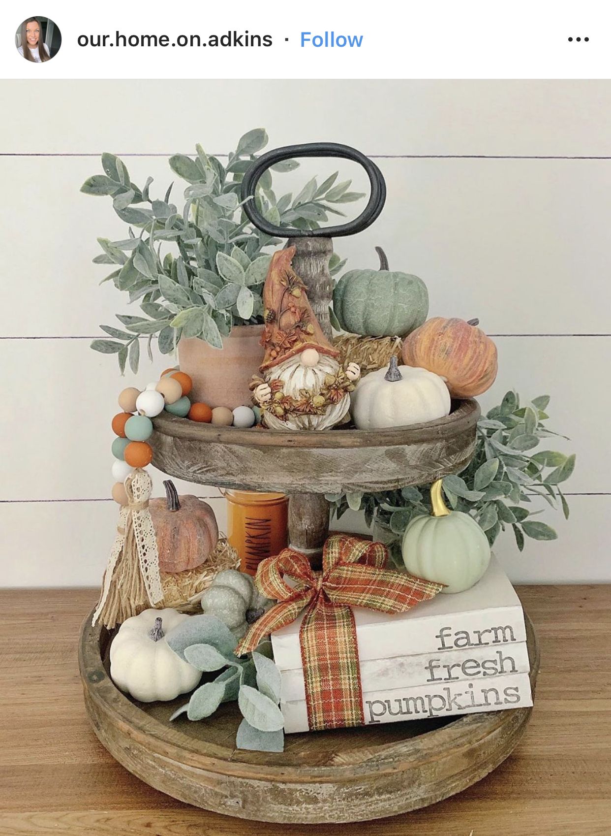 Two-tier wood tray styled with a fall gnome, sage and white pumpkins, eucalyptus, wood beads and a farm fresh pumpkins book stack
