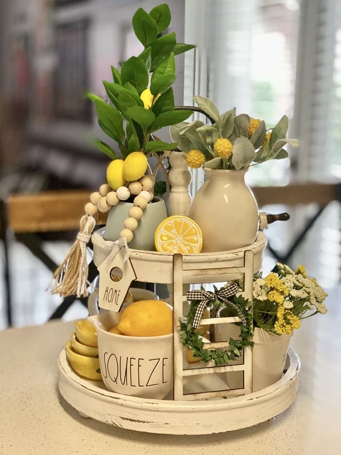 Two-tier white tray styled with lemons, a Squeeze bowl, a lemon slice dish and yellow wildflowers for summer
