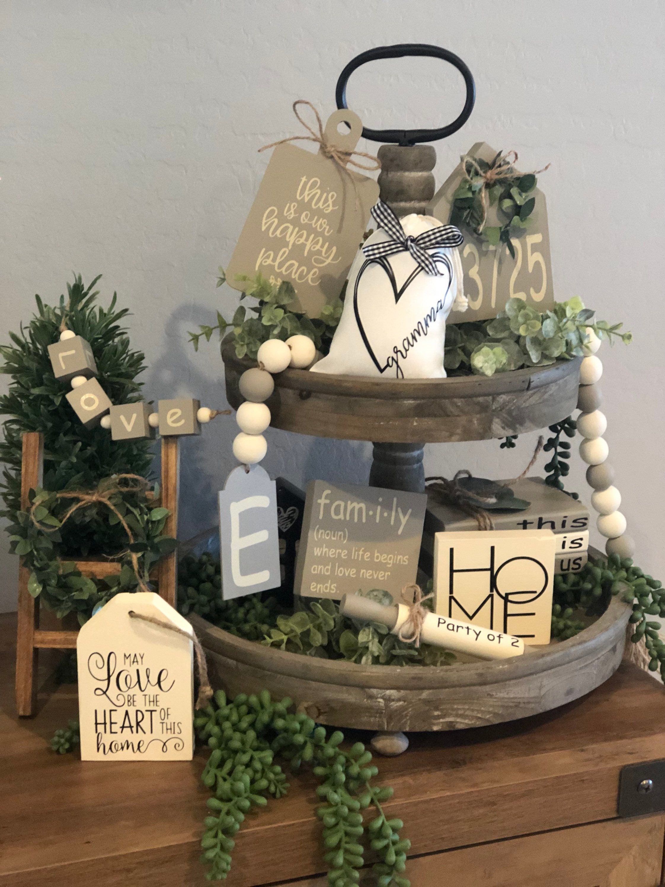 Two-tier wood tray mixing a fabric gift bag, wood letter blocks, house number tags and round wood beads for varied shapes