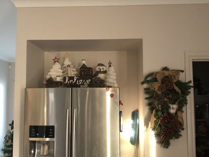 Christmas-themed decorative objects styled above a kitchen refrigerator