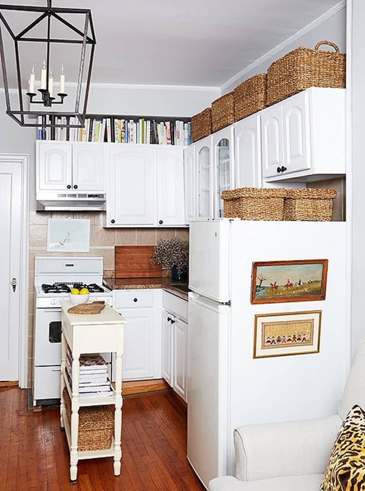 Woven baskets styled on top of white kitchen cabinets above a fridge